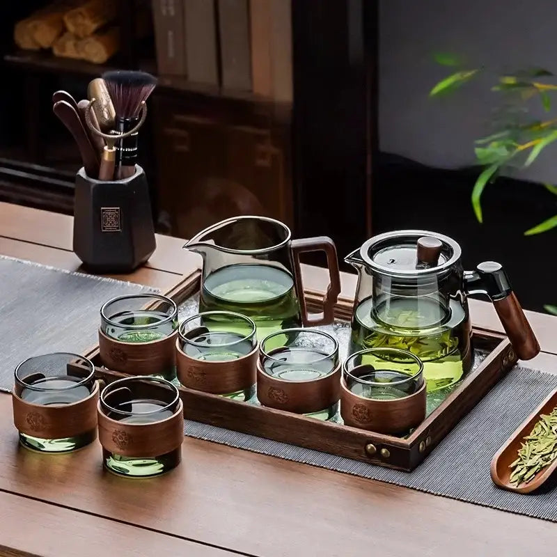 Clear glass tea set with wooden handle teapot and matching glasses on a retro glass tray by DecorBites