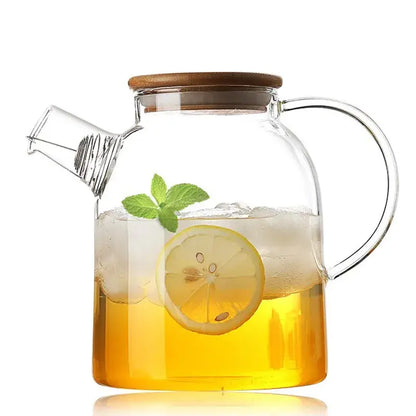 Clear glass teapot with wooden lid filled with iced lemon tea and mint leaves from decorbites glass teapot cold collection