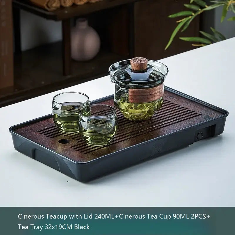 Black ceramic tea tray with dark wood grain finish and slatted drainage grooves for decorbites glass teapot set
