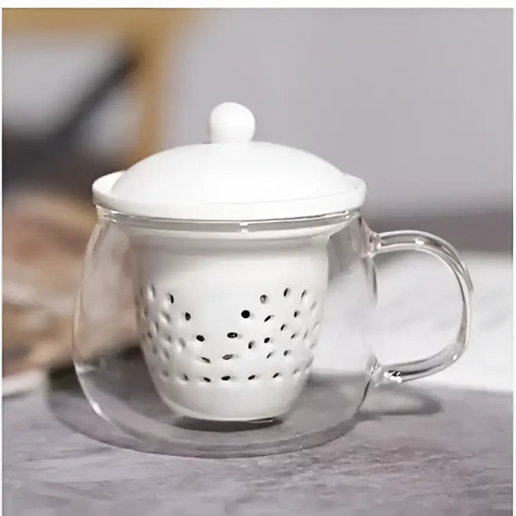 Clear glass teacup with white ceramic lid and matching perforated ceramic filter in decorbites glass teapot set