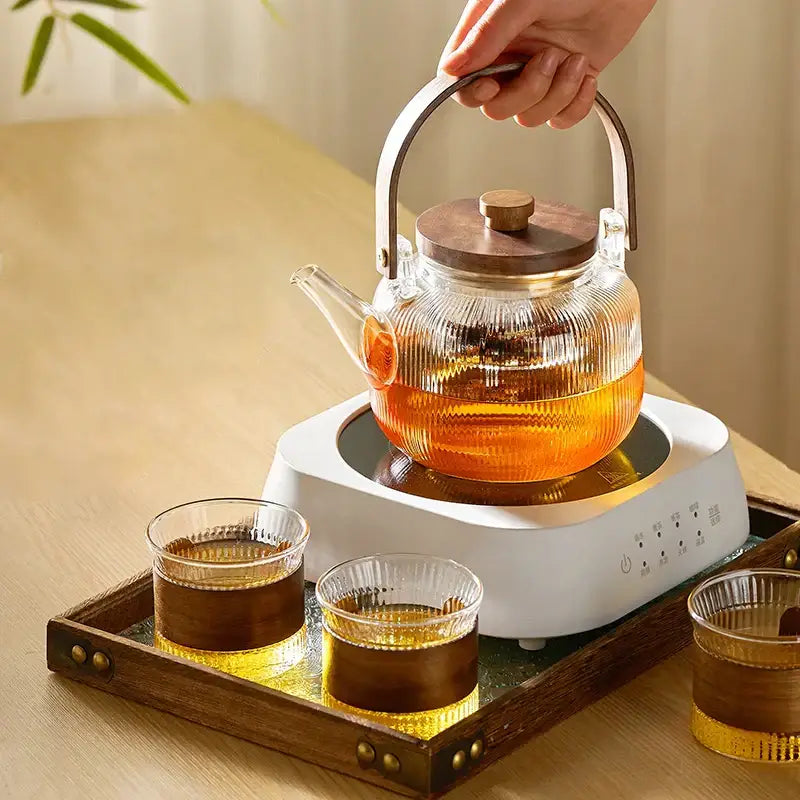 Clear ribbed glass teapot set with wooden handle and lid on electric base from DecorBites glass teapot collection