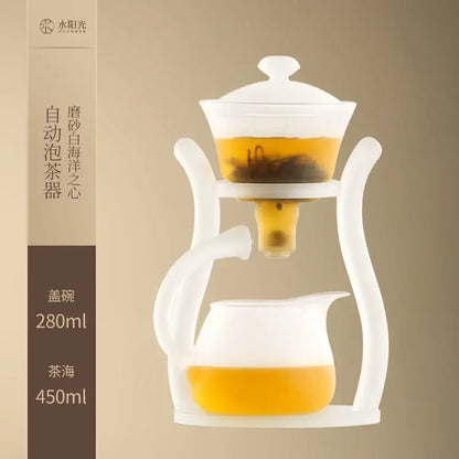 White ceramic glass teapot with frosted lid and handle featuring an automatic magnetic drip pot for brewing by DecorBites