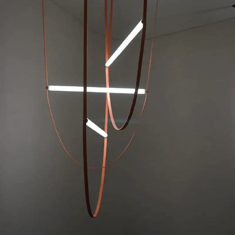 Modern minimalist pendant light with three glowing white LED tubes in a copper-toned decorbites glass tube pendant frame