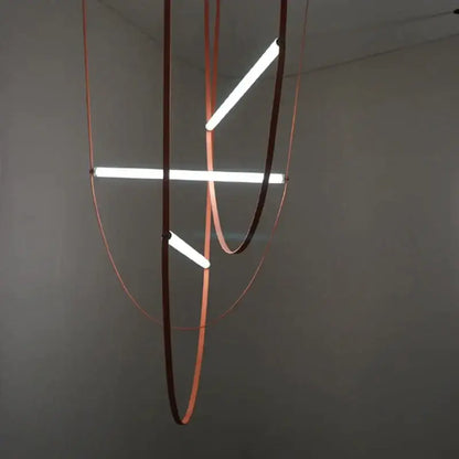 Modern minimalist pendant light with three glowing white LED tubes in a copper-toned decorbites glass tube pendant frame
