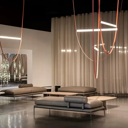 Modern taupe leather lounge sofa with minimalist metal frame shown alongside decorbites glass tube pendant light installation