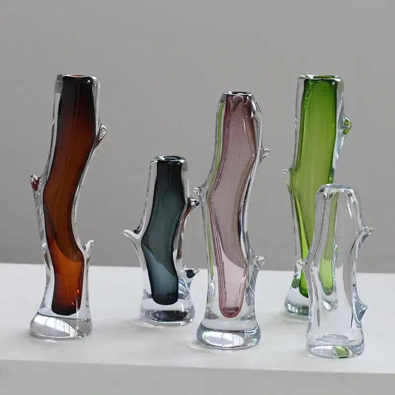 A collection of five decorbites glass vases in unique colors with tree-like thick branched shapes for floral arrangements