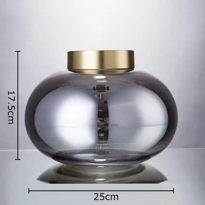 A decorbites glass vase desk decoration with a translucent gray glass body and polished gold-toned metal lid