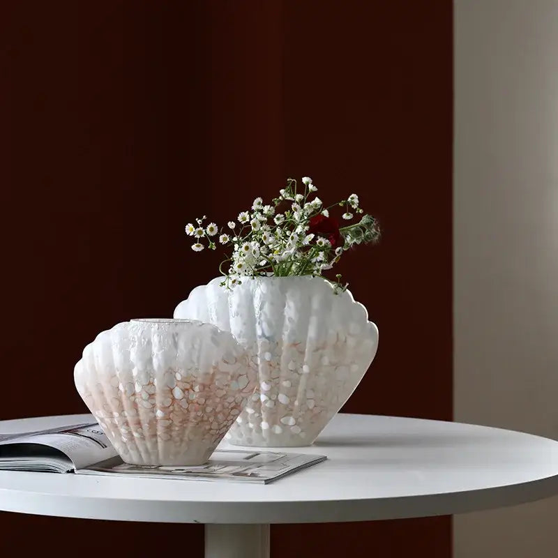 Two white shell-shaped ceramic DecorBites glass vases with textured surface and pinkish gradient for home decor