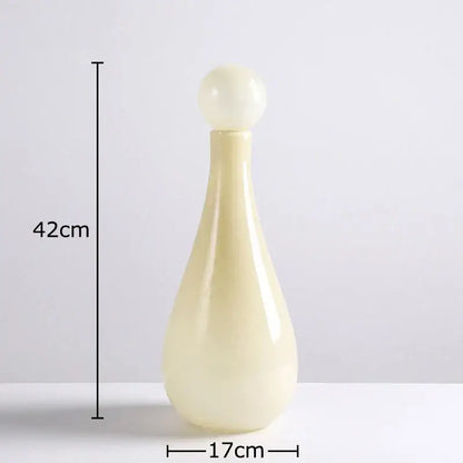 Cream-colored decorbites glass vase with smooth glossy finish and rounded stopper for vase flower arrangement