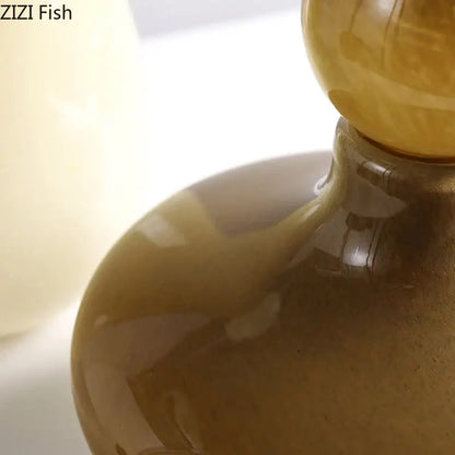 A translucent amber glass vase with a rounded body and spherical stopper for decorbites glass vase flower arrangement
