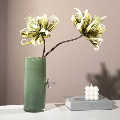 A sleek matte sage green decorbites glass vase geometric sphere with a clear spherical handle for flowers and accessories