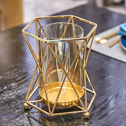 Gold geometric metal frame holding a clear DecorBites glass vase metal cylinder for flower arrangement and wedding decor