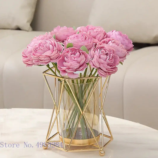 A decorbites glass vase with pink artificial peonies encased in a gold metal frame geometric flower arrangement