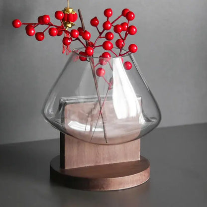 Clear glass vase terrarium by decorbites with wooden base holding red berry branches for home decoration