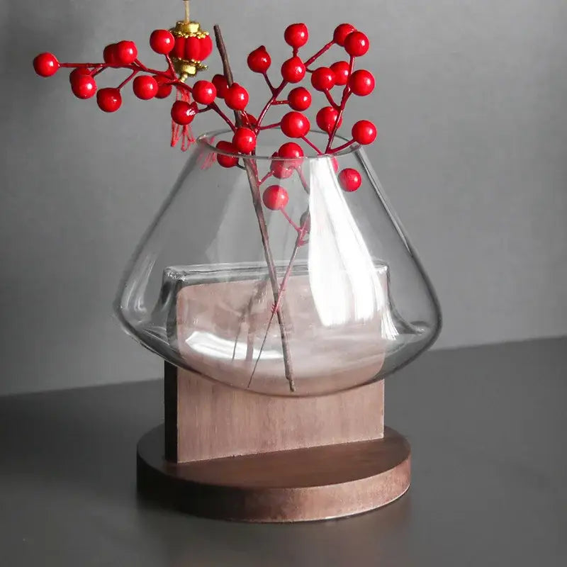 Clear glass vase terrarium by decorbites with wooden base holding red berry branches for home decoration