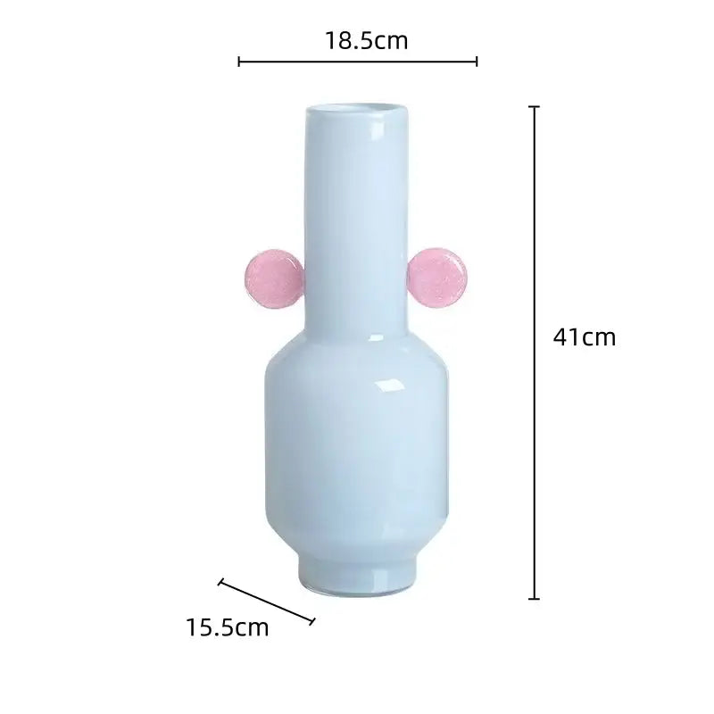 A sleek light blue ceramic decorbites glass vase with two pink spherical handles for floral arrangement accessory