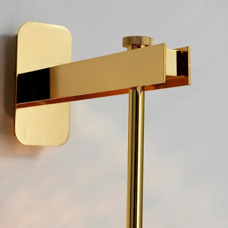 Gold-toned modern wall-mounted toilet paper holder with brushed metal finish complements DecorBites™ glass wall art light