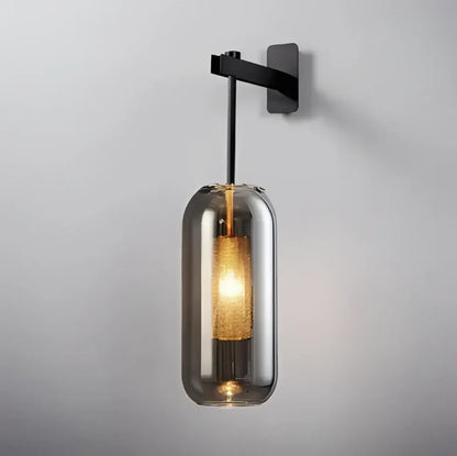 Black metal glass wall art light with smoked glass cylinder and illuminated golden mesh filament bulb for modern decor