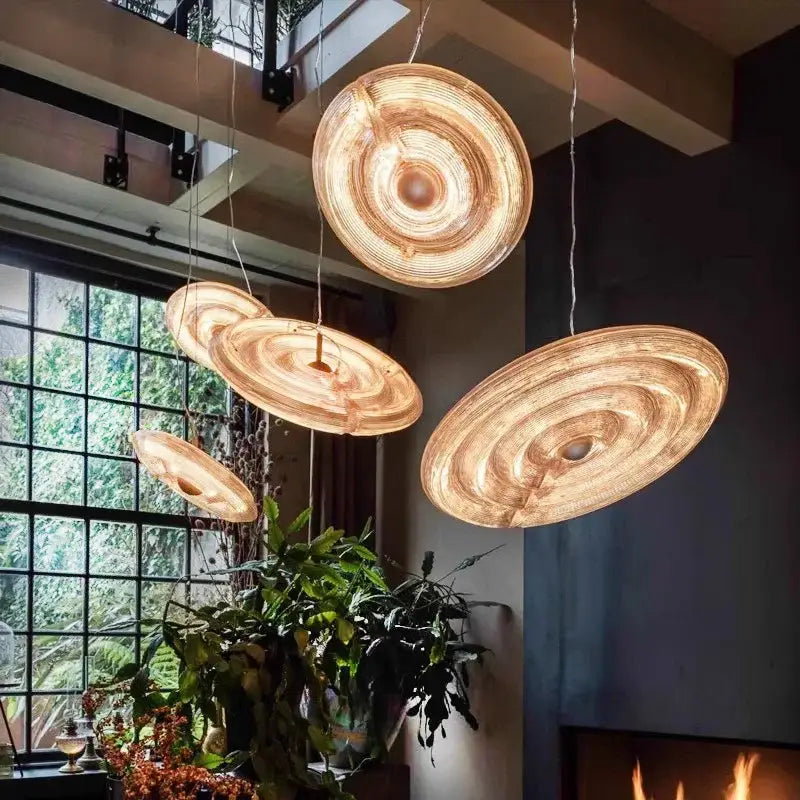 Warm-toned circular wooden pendant lights with concentric rings complement decorbites glass wall lamp for living room