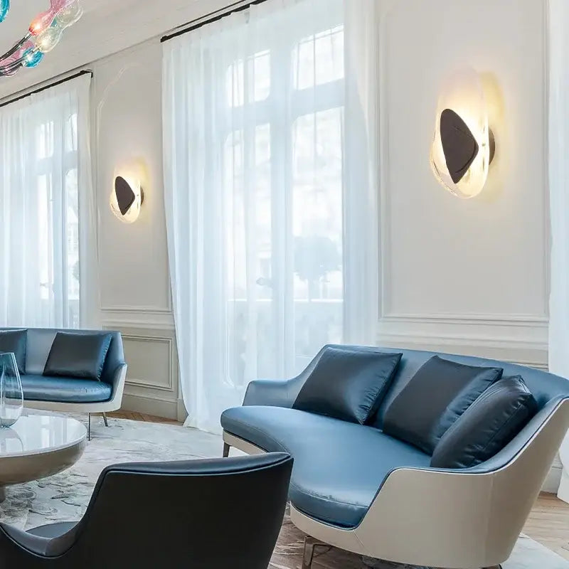 Modern blue leather sofa with sleek white frame and dark cushions beside decorbites glass wall lamp led sconce