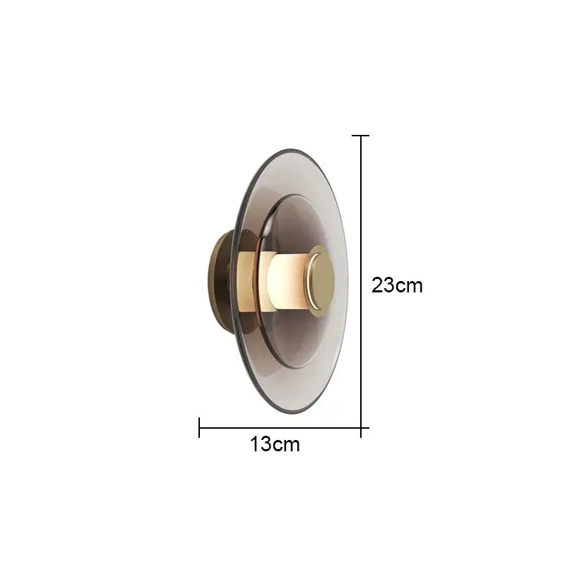 Modern minimalist DecorBites glass wall lamp with frosted glass shade and brass accents emitting warm light