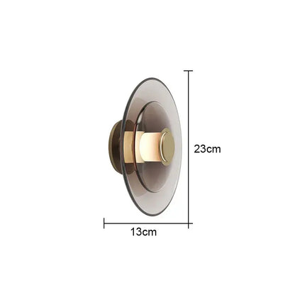 Modern minimalist DecorBites glass wall lamp with frosted glass shade and brass accents emitting warm light