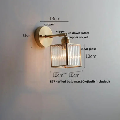 A modern copper decorbites glass wall light sconce with a clear ridged glass cube and adjustable rotating socket