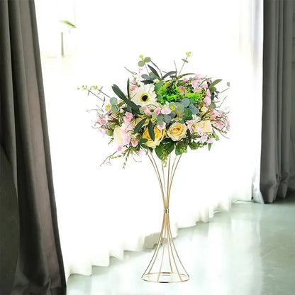 A gold-toned iron flower vase set by decorbites holding soft pink yellow and white artificial flowers for wedding decor
