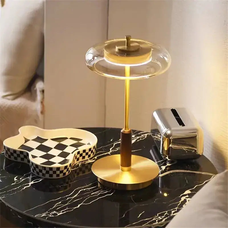 A modern decorbites gold lustre glass mushroom table lamp with a brass base and illuminated circular light for bedrooms