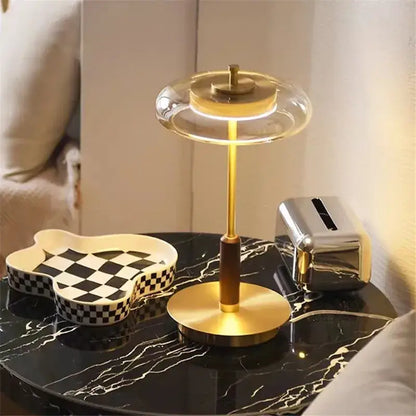 A modern decorbites gold lustre glass mushroom table lamp with a brass base and illuminated circular light for bedrooms