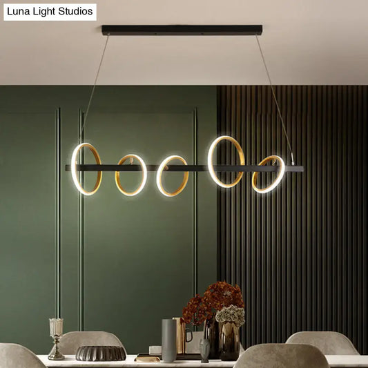 Modern black and gold metal ceiling pendant with simple circles design and warm light for dining room island illumination