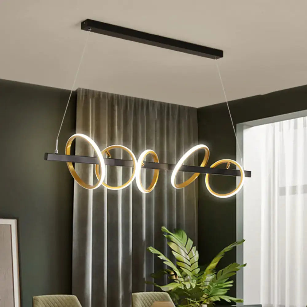 Modern black and gold metal ceiling pendant with simple circles design and glowing LEDs for dining room island lighting