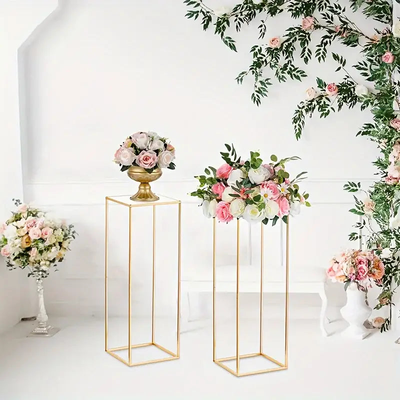 Decorbites gold metal vase set featuring gold metal floral stands with pink and white roses in ornate urns for events