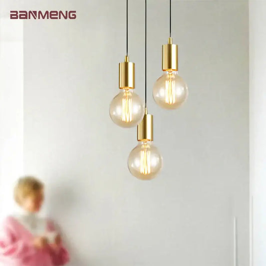 Gold modern pendant light by decorbites featuring clear glass bulb housings and visible filament bulbs for dining room use