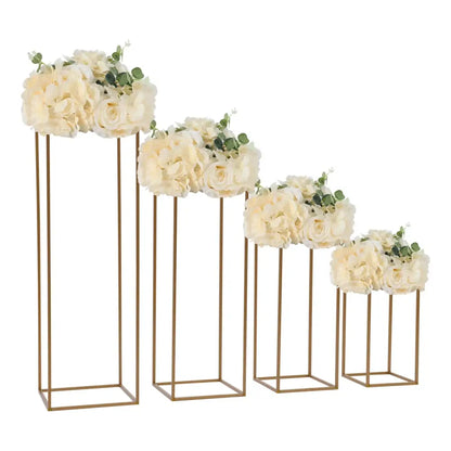 Set of four gold-toned metal flower vase stands with cream artificial flowers for elegant gold wedding decor by DecorBites™