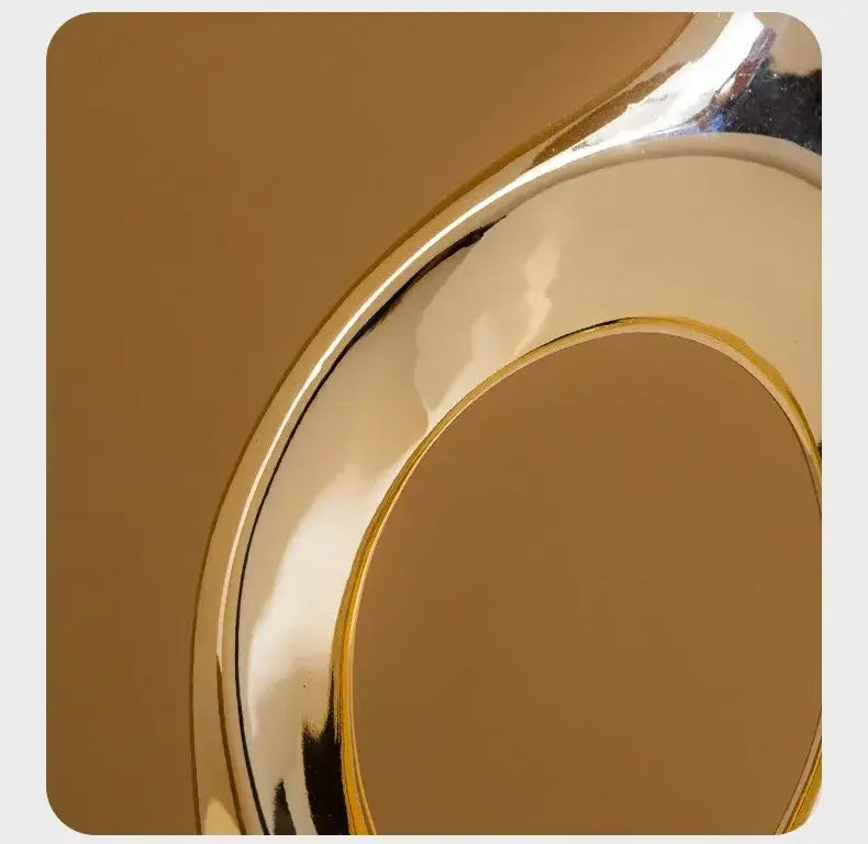 A sleek gold-toned metal ring with a smooth reflective surface complements the decorbites golden flower vase accessory