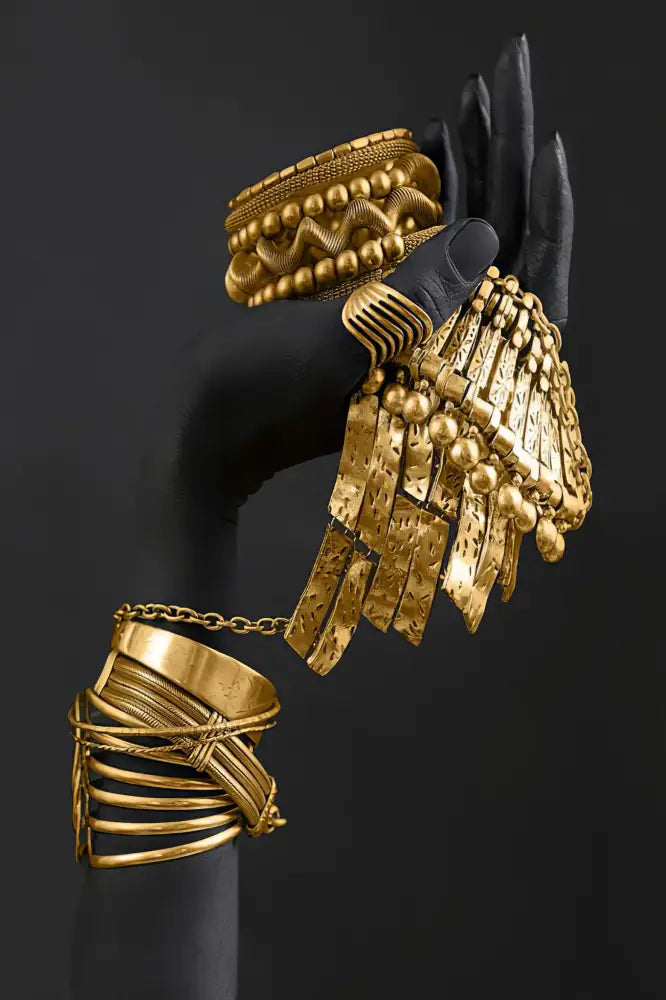 A bold gold-toned wing-inspired bracelet with layered metallic plates and dangling beads from decorbites golden jewelry african collection
