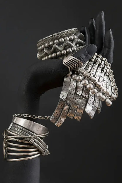 A silver fringe bracelet with dangling beads and hammered plates featured in decorbites golden jewelry african woman canvas art