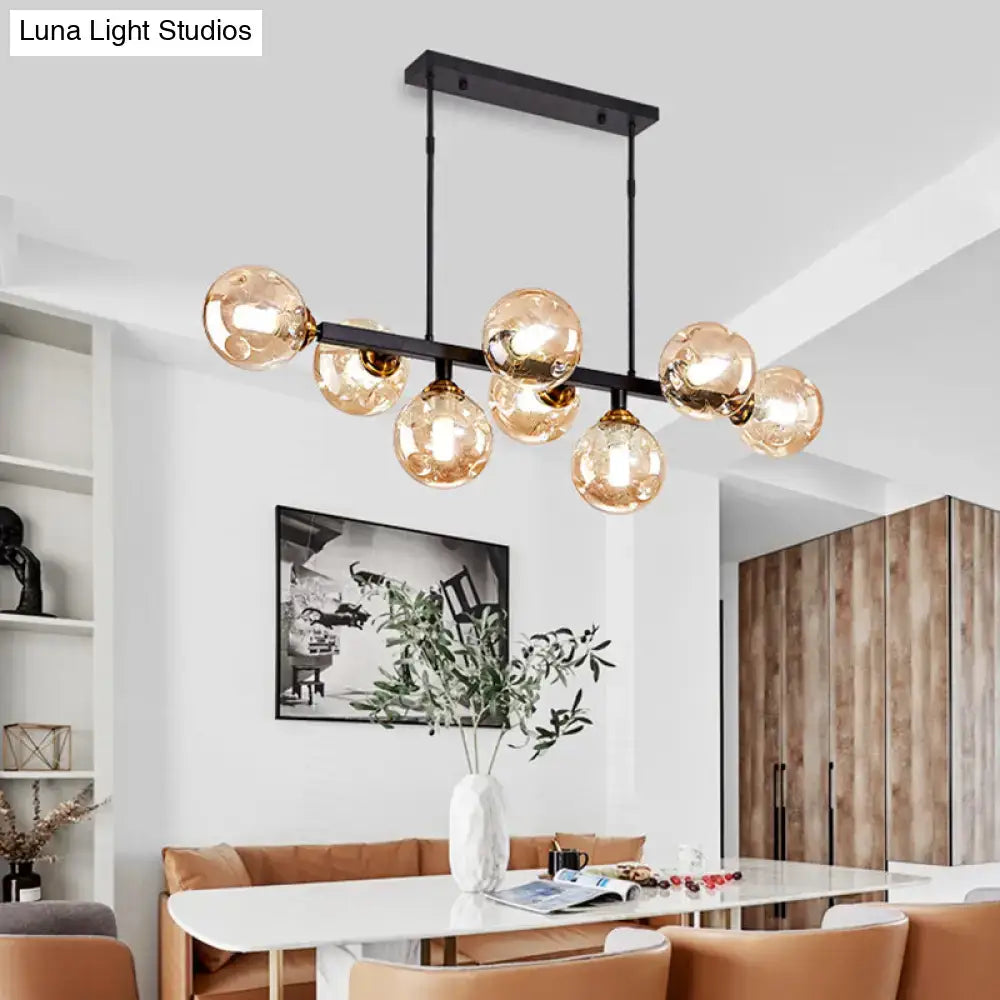 Modern black metal chandelier with multiple amber hand-blown dimpled glass globe bulbs for restaurant lighting