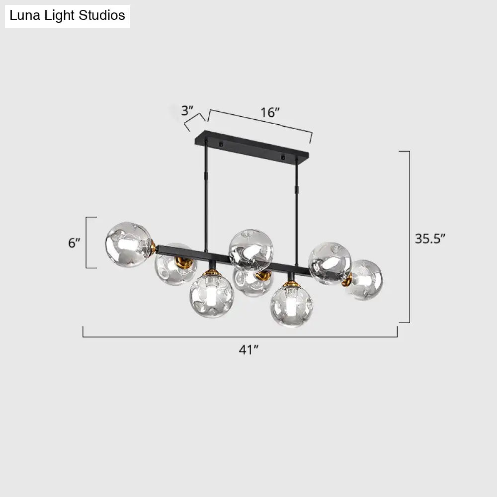 Modern black metal chandelier with six clear hand-blown dimpled glass globe bulbs and gold-toned accents for restaurant use