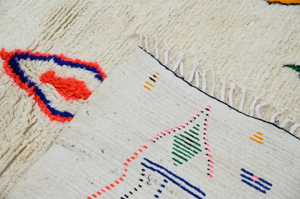 Cream-colored handmade moroccan azilal carpet with vibrant red blue green and yellow geometric patterns 240x160 cm