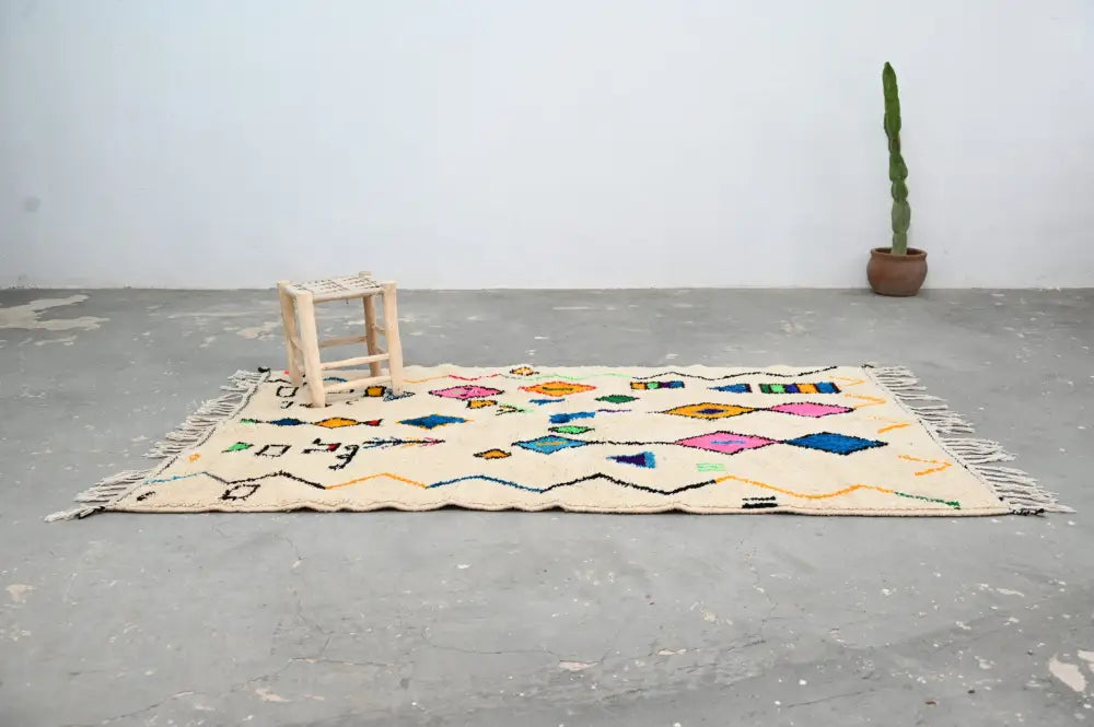 Beige handmade moroccan azilal rug with colorful geometric patterns and fringed edges 222 x 139 cm decorbites