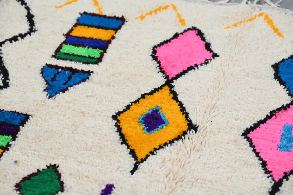 Decorbites™ handmade moroccan azilal rug with plush off-white base and vibrant geometric patterns in bold colors
