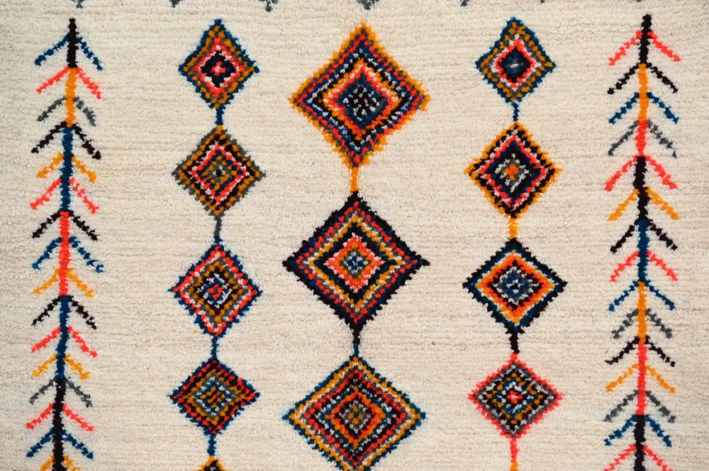 Beige handmade moroccan azilal rug with intricate geometric patterns in vibrant orange red blue and black 236x155cm