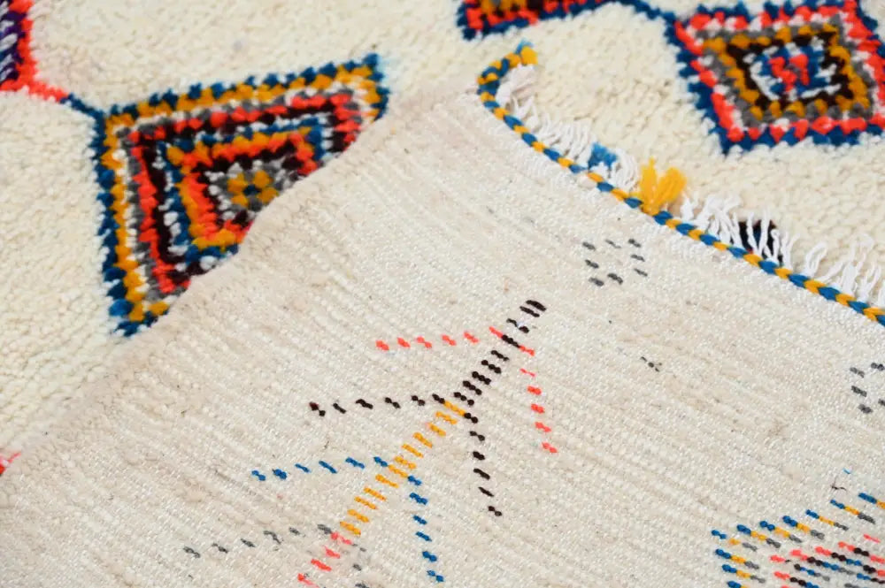 Beige woven decorbites handmade moroccan azilal rug with colorful red blue orange and black geometric patterns 236x155cm