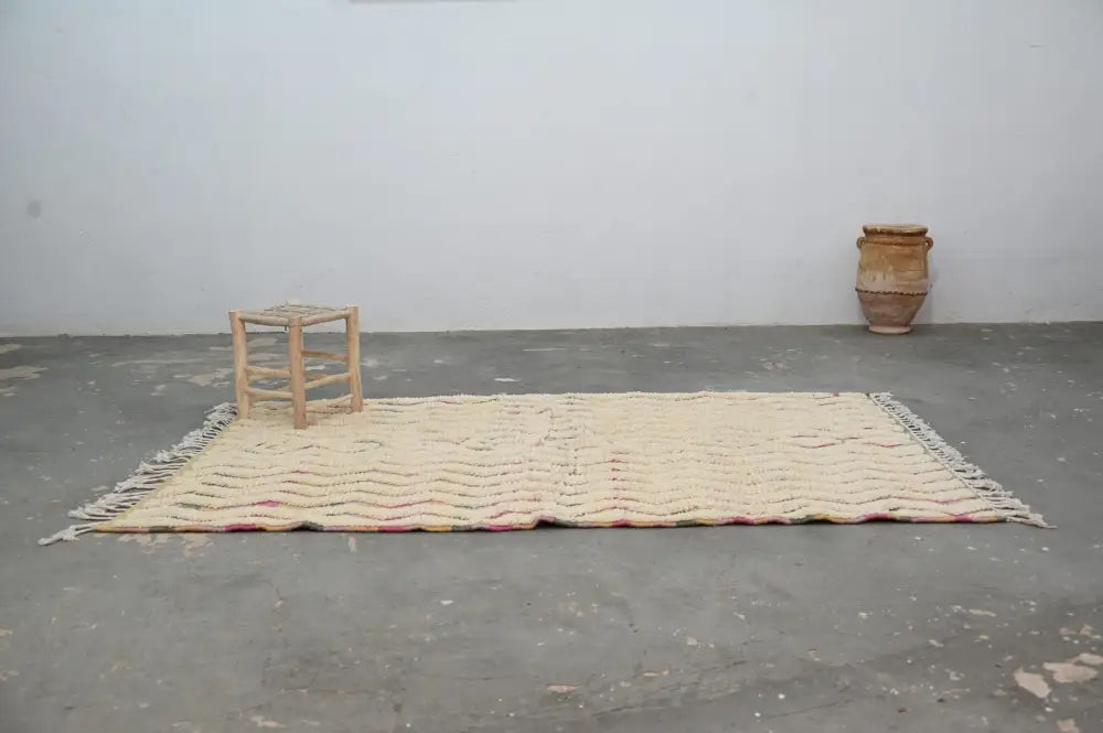 Cream-colored handmade moroccan azilal rug with textured wavy pattern and fringed edges 238x144cm decorbites