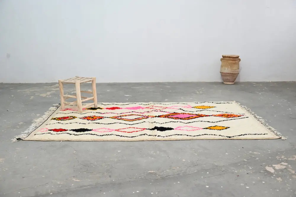 Cream-colored DecorBites™ handmade azilal rug 240x150cm with bold pink orange black yellow geometric patterns in natural wool