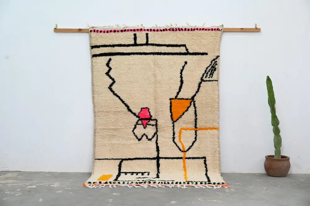 Beige woven decorbites™ handmade moroccan azilal rug with bold black orange pink geometric patterns and fringed edges