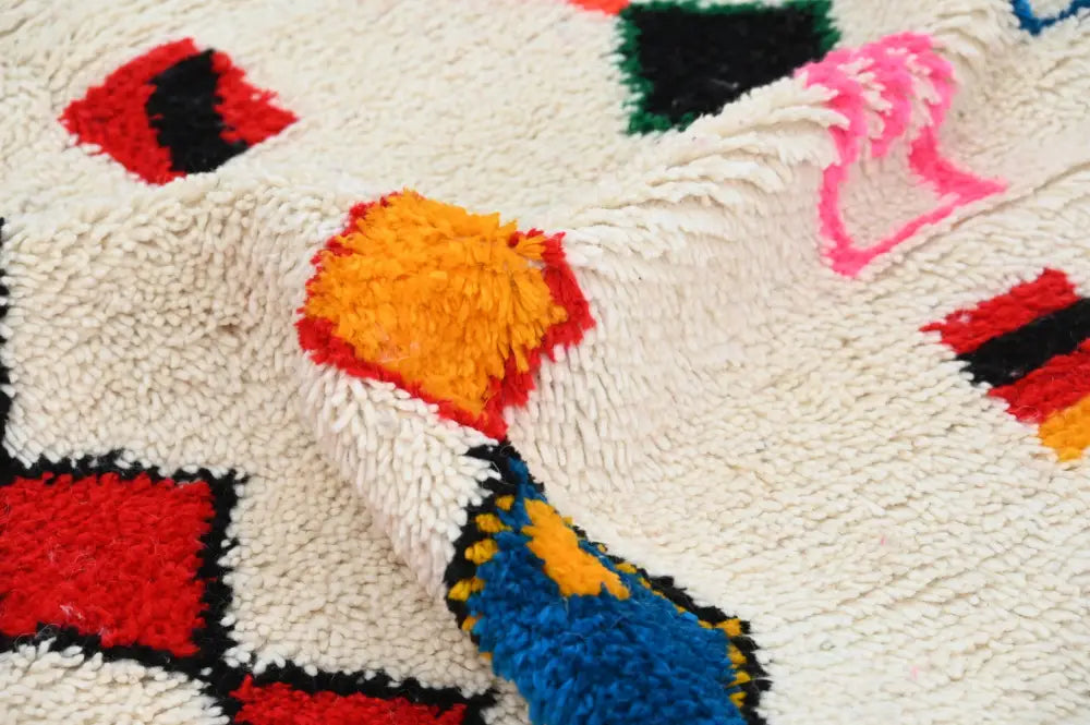 A cream-colored plush decorbites handmade traditional azilal rug with vibrant geometric patterns 242x140cm