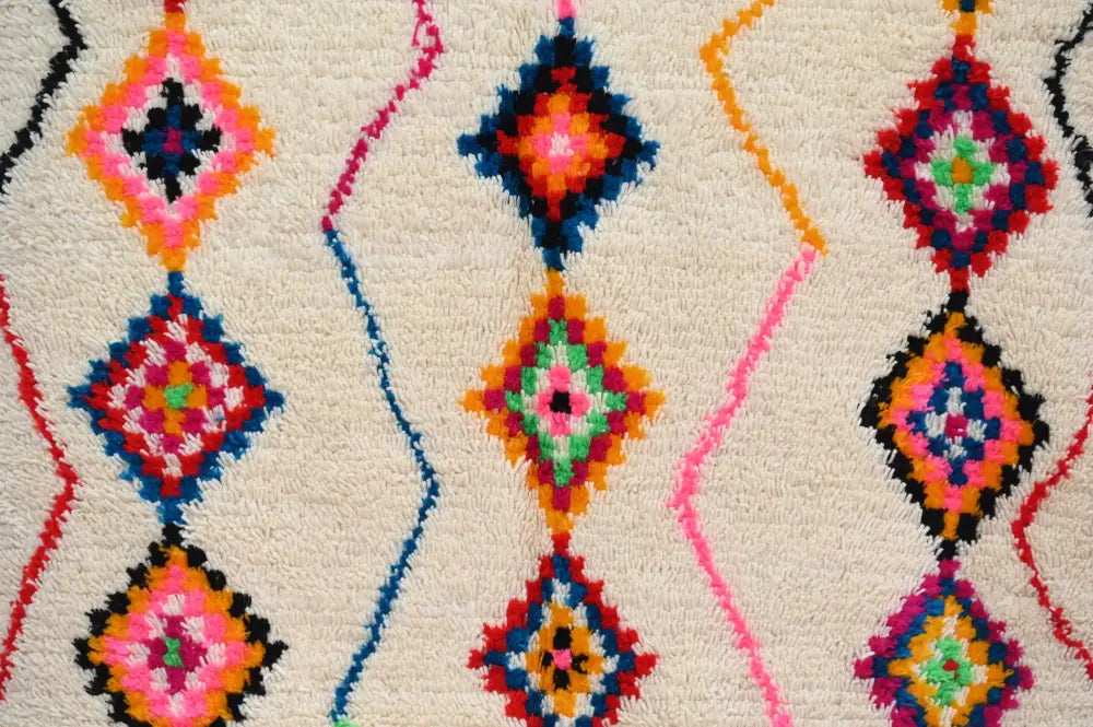 DecorBites™ handmade Moroccan azilal rug with fluffy cream base and vibrant multicolored traditional azilal diamond motifs